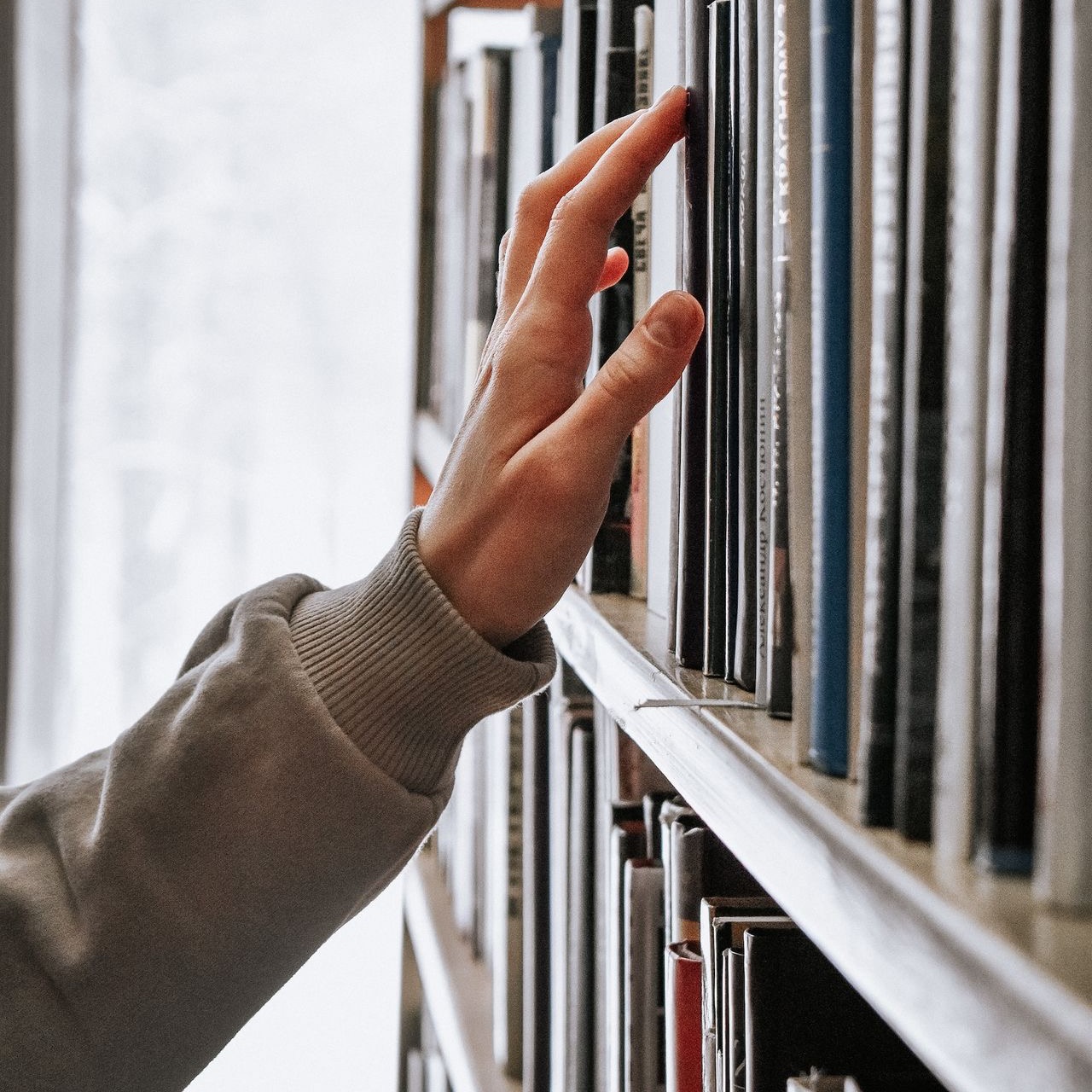 person in white long sleeve shirt holding white book